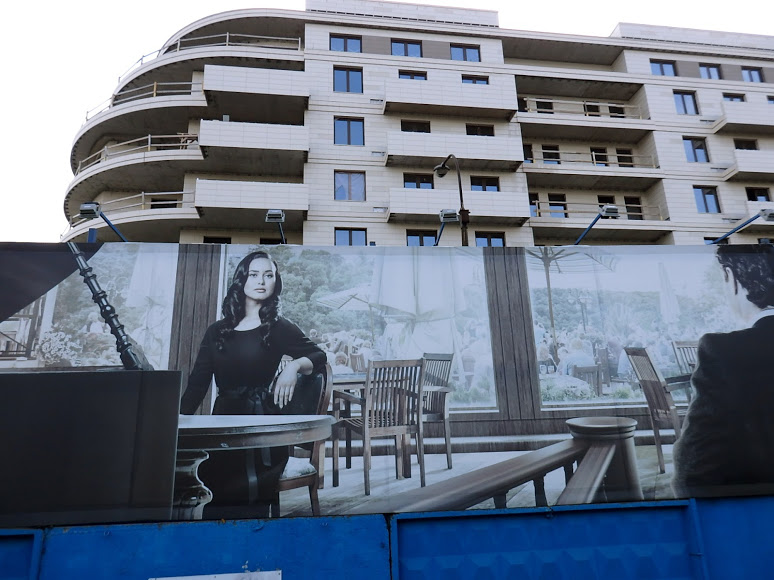 The large hoardings that double as a construction site fence are chockablock with stock images of god knows who enjoying lives of "privilege" god knows where.